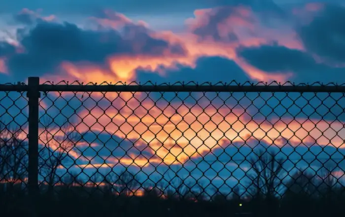 A fence silhouetted against a sunset, symbolizing the confinement of fentanyl withdrawal symptoms.