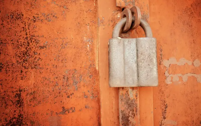 An old padlock on a rusty metal surface, representing the impact of kratom on the liver and health risks.